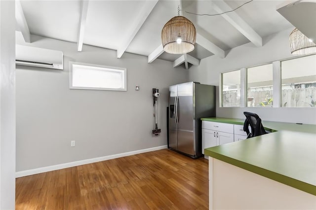 kitchen with beamed ceiling, stainless steel refrigerator with ice dispenser, white cabinets, and a wall unit AC