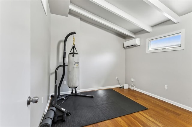 exercise room with an AC wall unit and hardwood / wood-style floors