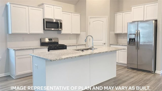 kitchen featuring white cabinets, appliances with stainless steel finishes, and a center island with sink