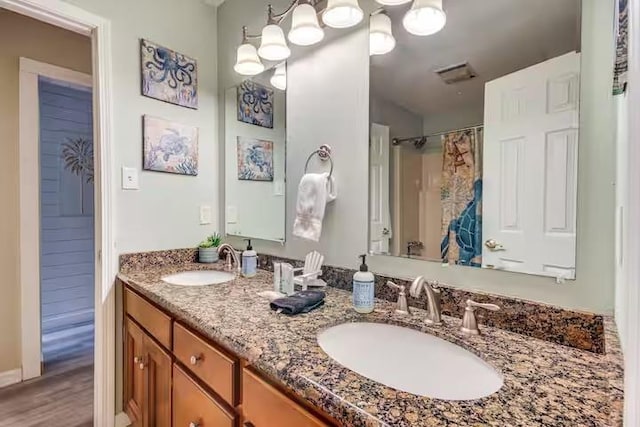 bathroom with curtained shower, vanity, and wood-type flooring