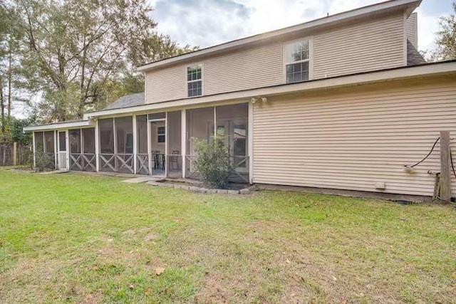 back of property with a sunroom and a yard