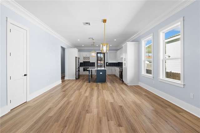 kitchen with pendant lighting, a center island, white cabinets, stainless steel fridge, and tasteful backsplash