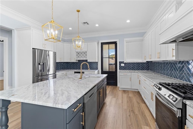 kitchen featuring appliances with stainless steel finishes, custom exhaust hood, sink, white cabinetry, and an island with sink