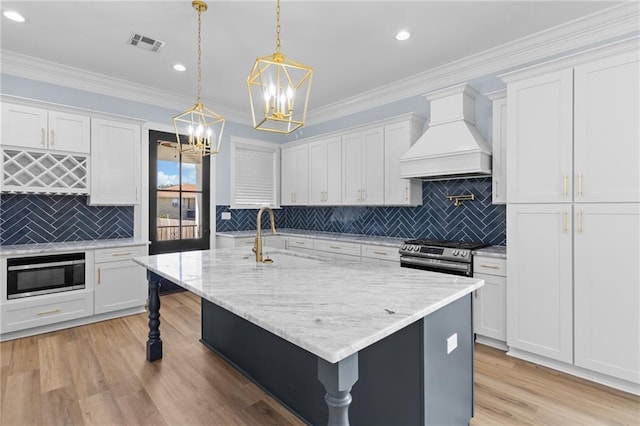 kitchen featuring stainless steel range oven, white cabinetry, and custom exhaust hood