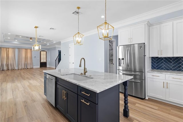 kitchen featuring decorative backsplash, stainless steel appliances, sink, white cabinetry, and hanging light fixtures