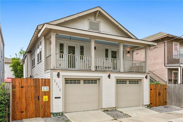 view of front facade featuring a garage, a balcony, and covered porch