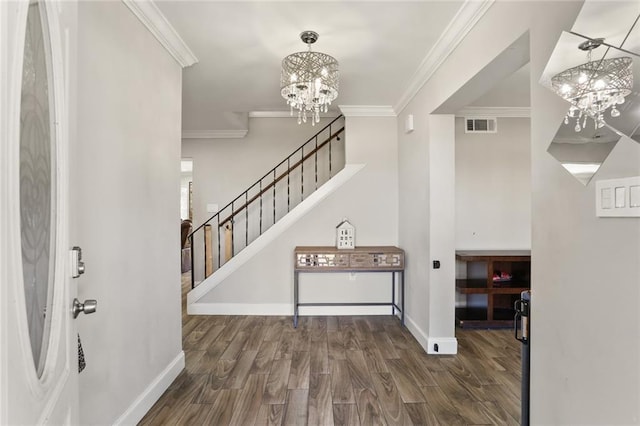 foyer entrance with dark wood-type flooring, an inviting chandelier, and crown molding