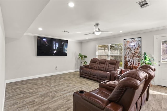 cinema room featuring hardwood / wood-style flooring, ceiling fan, and ornamental molding