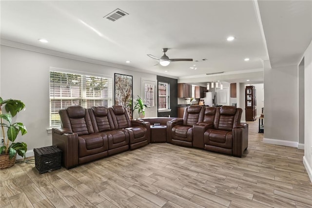 cinema featuring crown molding, light hardwood / wood-style flooring, and ceiling fan