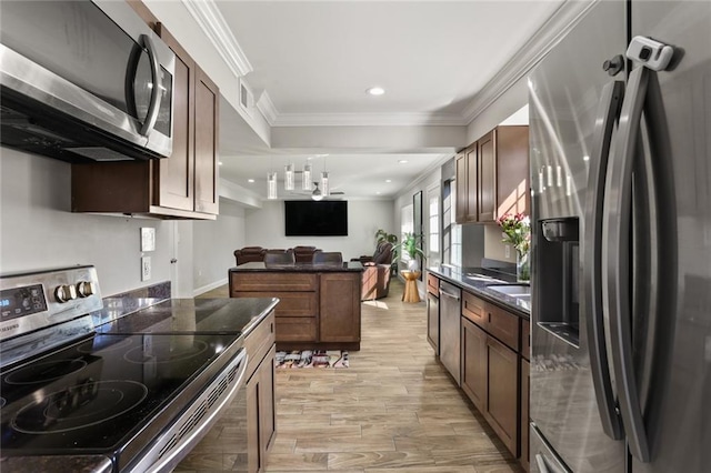 kitchen with appliances with stainless steel finishes, light wood-type flooring, ceiling fan, crown molding, and pendant lighting