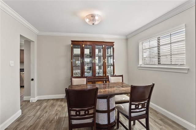 dining area featuring crown molding and hardwood / wood-style flooring