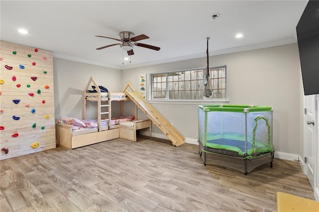 rec room featuring hardwood / wood-style flooring, ceiling fan, and crown molding