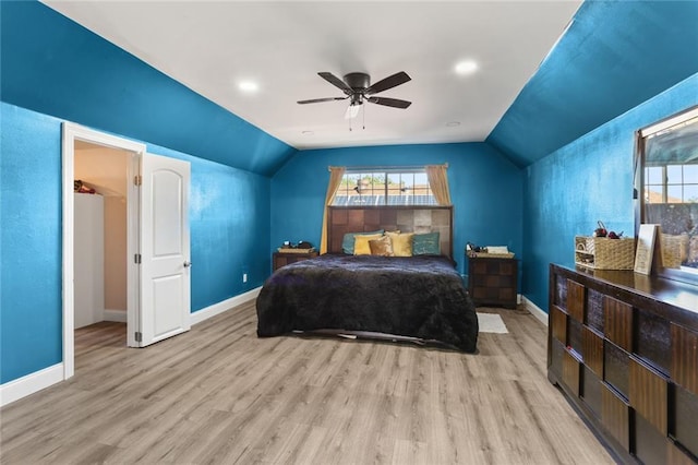 bedroom with ceiling fan, vaulted ceiling, and light wood-type flooring