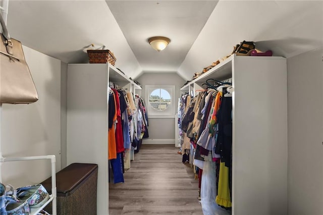 walk in closet featuring hardwood / wood-style flooring and vaulted ceiling