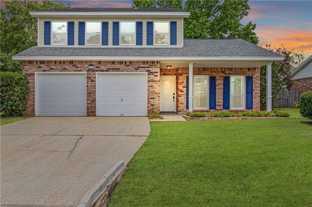 view of front of house with brick siding, fence, concrete driveway, a front yard, and a garage