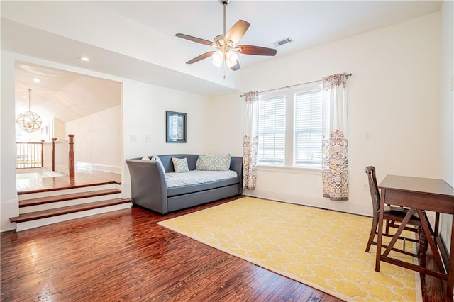 living room featuring hardwood / wood-style floors, ceiling fan with notable chandelier, and vaulted ceiling