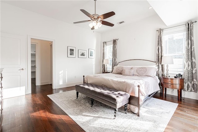 bedroom featuring a walk in closet, ceiling fan, and hardwood / wood-style flooring