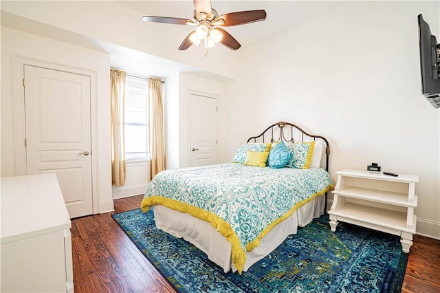 bedroom with dark hardwood / wood-style flooring and ceiling fan