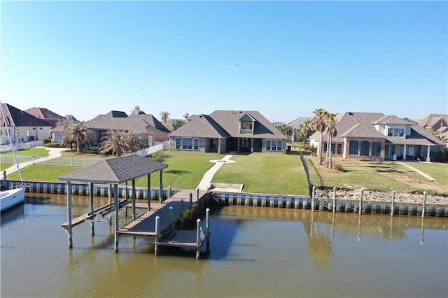 dock area with boat lift, a residential view, a lawn, and a water view