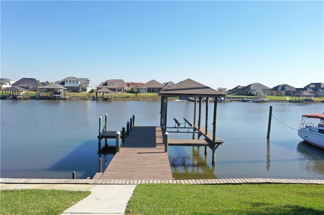 view of dock with boat lift, a residential view, and a water view