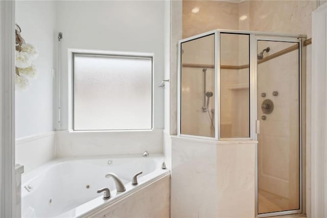 bathroom with a wealth of natural light and shower with separate bathtub