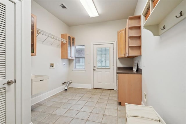 washroom with hookup for a gas dryer, cabinets, light tile patterned floors, hookup for a washing machine, and electric dryer hookup