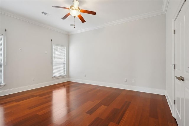 empty room with baseboards, wood finished floors, visible vents, and ornamental molding