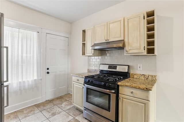 kitchen featuring light stone counters, stainless steel range with gas stovetop, tasteful backsplash, and light tile patterned floors