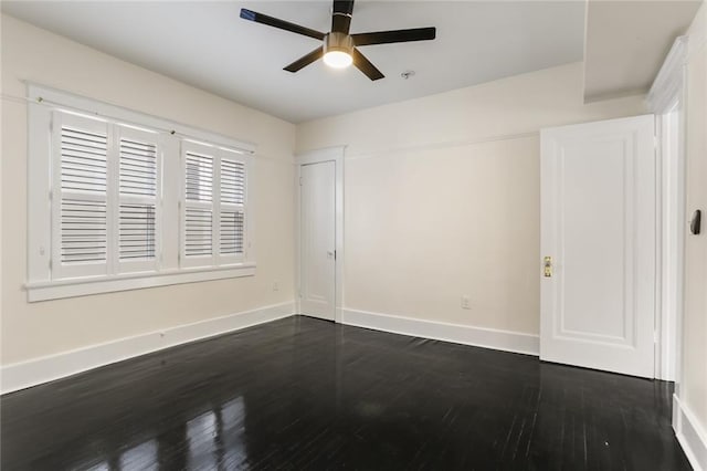 empty room with ceiling fan and dark hardwood / wood-style flooring