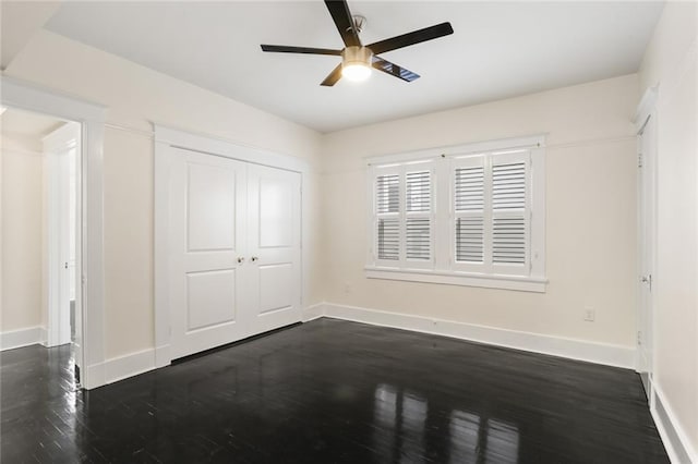 unfurnished bedroom featuring dark wood-type flooring, a closet, and ceiling fan