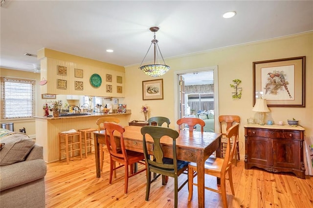 dining space featuring ornamental molding and light wood-type flooring