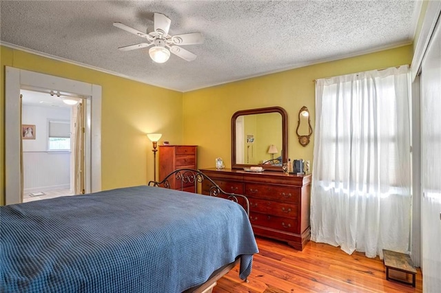 bedroom with ceiling fan, a textured ceiling, and light wood-type flooring