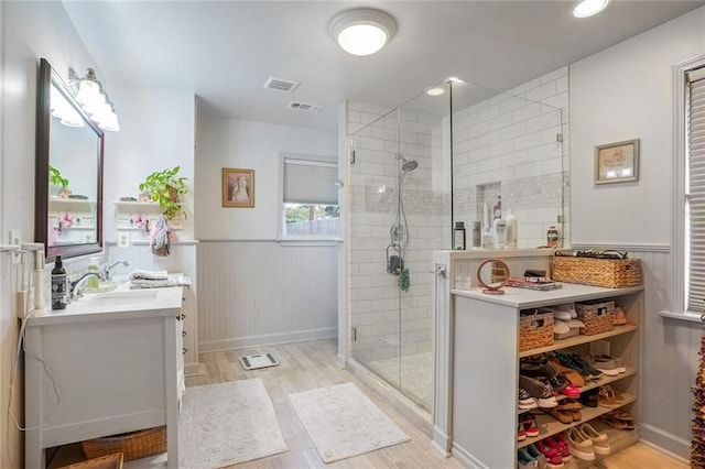 bathroom featuring vanity, a shower with shower door, and wood-type flooring