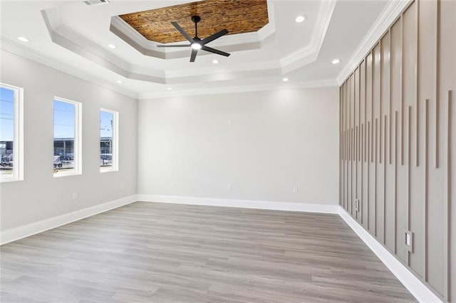 empty room featuring a tray ceiling, ceiling fan, and ornamental molding