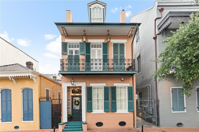 918 Orleans Ave, New Orleans, LA 70116 - view of front of home featuring a balcony, a gate, stucco siding, and a chimney