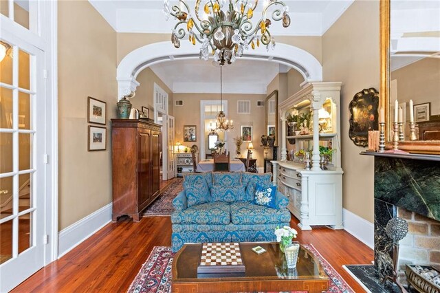 918 Orleans Ave, New Orleans, LA 70116 - living area with arched walkways, baseboards, a chandelier, and wood finished floors
