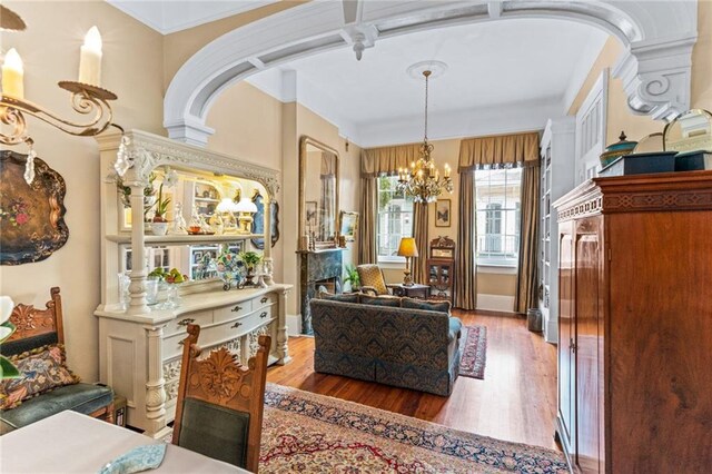 918 Orleans Ave, New Orleans, LA 70116 - living area with arched walkways, wood finished floors, a chandelier, and crown molding