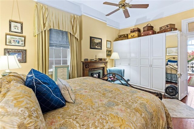 918 Orleans Ave, New Orleans, LA 70116 - bedroom featuring a fireplace, crown molding, wood finished floors, and ceiling fan