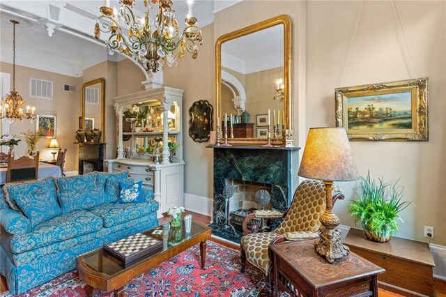 918 Orleans Ave, New Orleans, LA 70116 - living room featuring a notable chandelier, baseboards, a premium fireplace, and visible vents