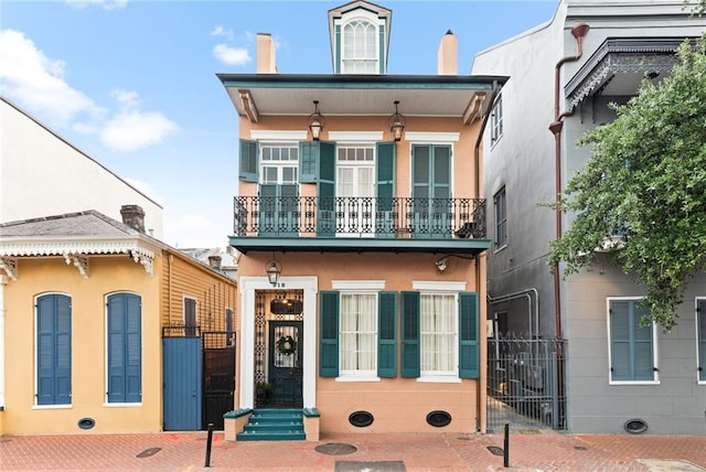918 Orleans Ave, New Orleans, LA 70116 - view of front of property with stucco siding, a gate, and a balcony