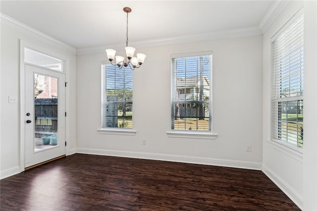 unfurnished dining area with plenty of natural light, dark hardwood / wood-style floors, ornamental molding, and a chandelier