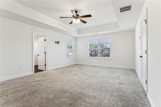 unfurnished bedroom with a tray ceiling, ceiling fan, carpet floors, and ornamental molding