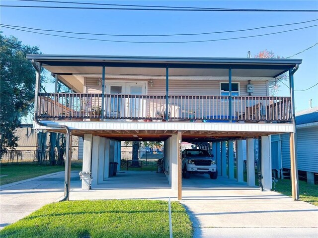 view of front of home with covered porch, a carport, and driveway