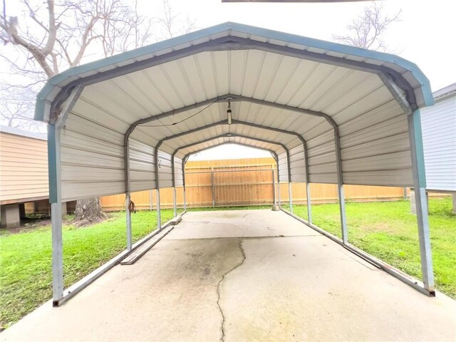 view of car parking with fence and a carport