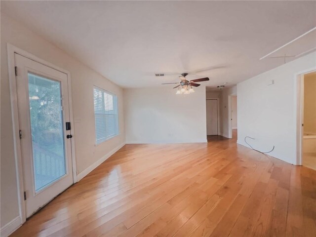 spare room featuring attic access, visible vents, ceiling fan, and light wood-style flooring