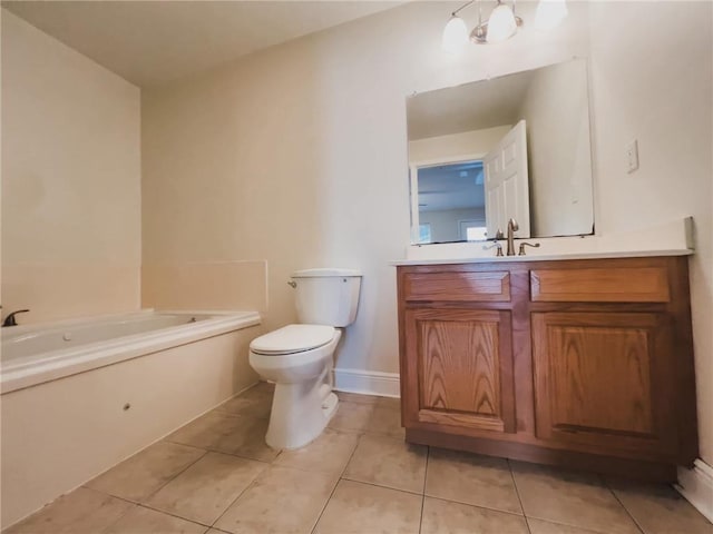 bathroom featuring baseboards, toilet, tile patterned floors, vanity, and a bath