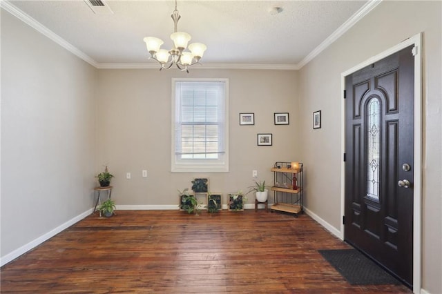 entrance foyer featuring dark hardwood / wood-style flooring, ornamental molding, and a notable chandelier