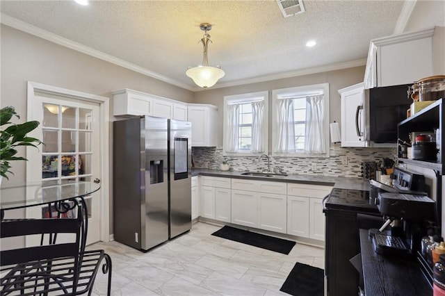 kitchen with a textured ceiling, stainless steel appliances, sink, decorative light fixtures, and white cabinetry