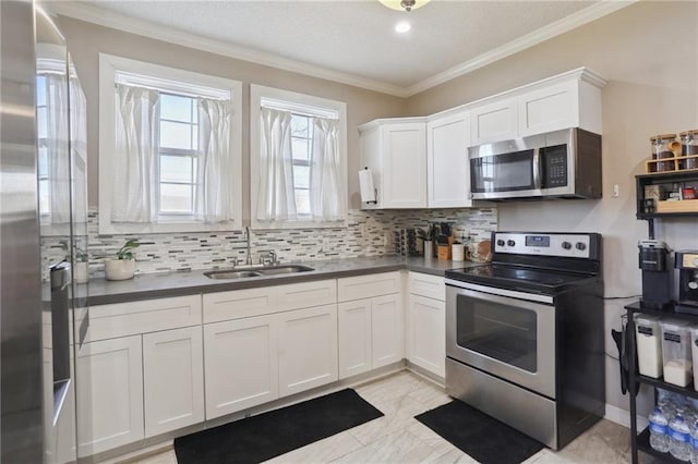 kitchen featuring tasteful backsplash, sink, white cabinets, and stainless steel appliances