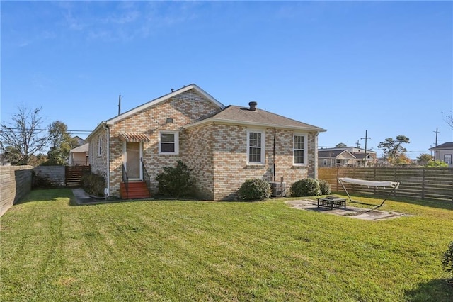 rear view of house with a yard, an outdoor fire pit, and central air condition unit